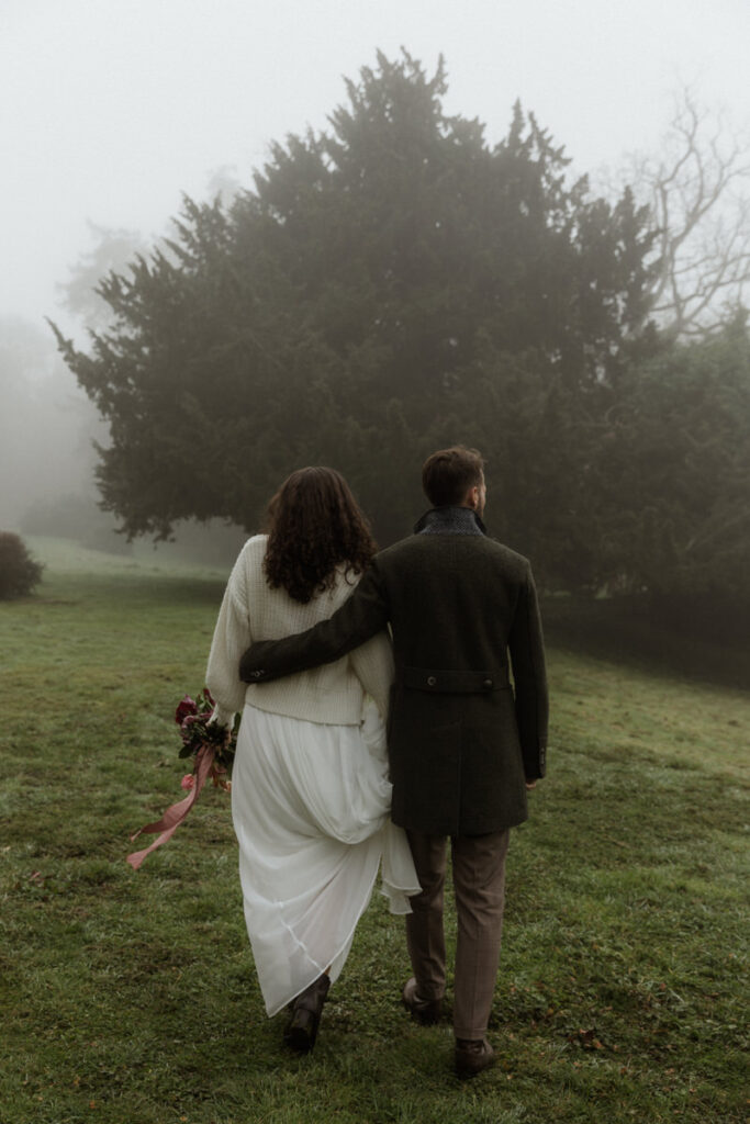 mariés qui marchent dans le brouillard elopement hivernal château Pordor