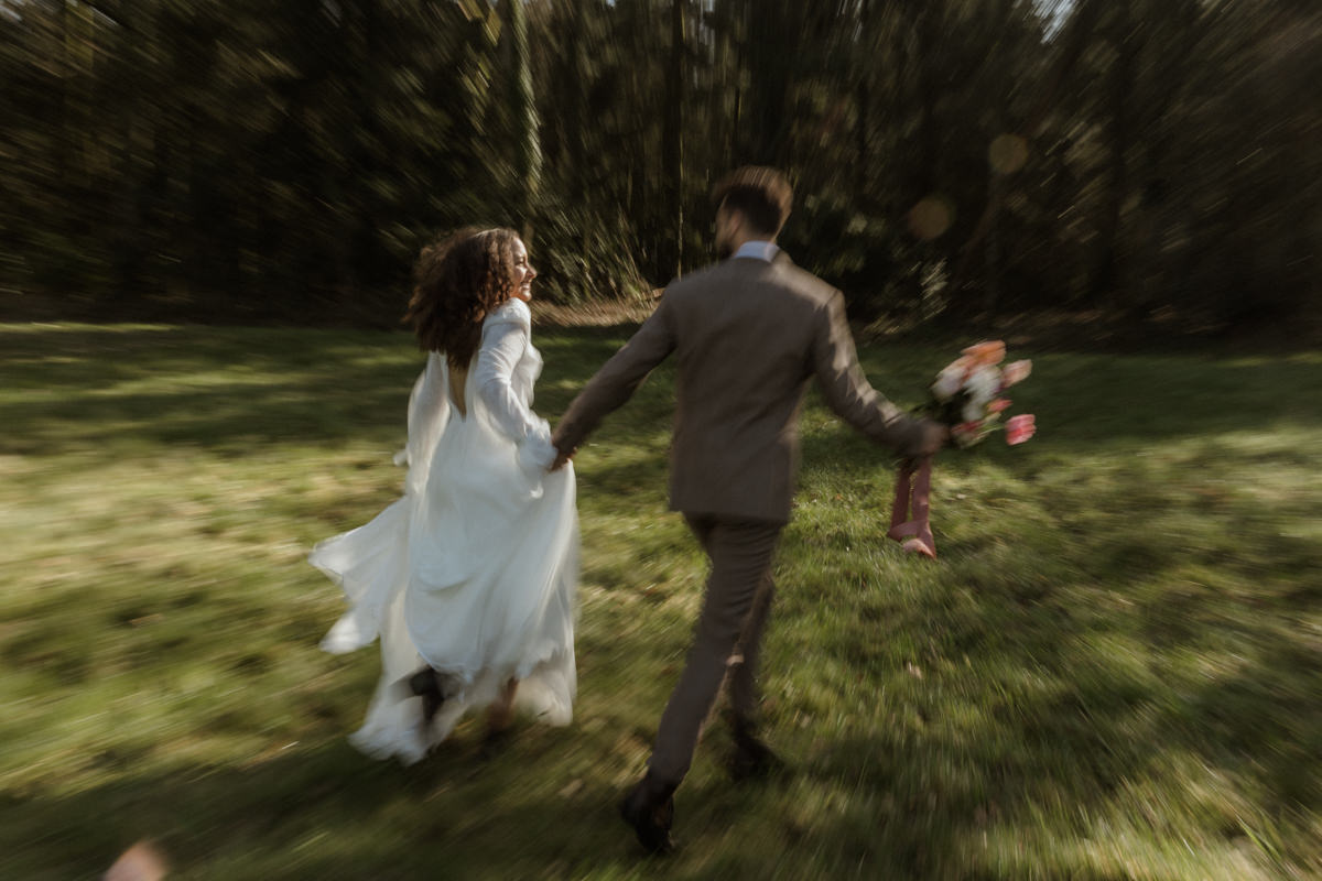 photo floue des mariés qui courent dans le parc du château