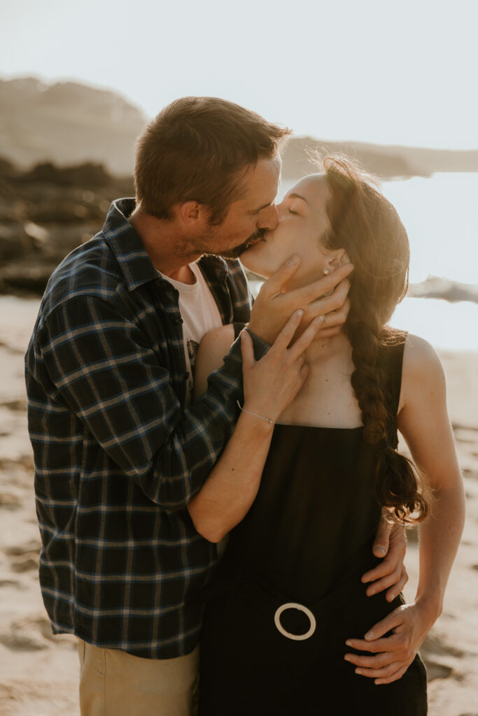 couple qui s'embrasse sur la plage au coucher du soleil